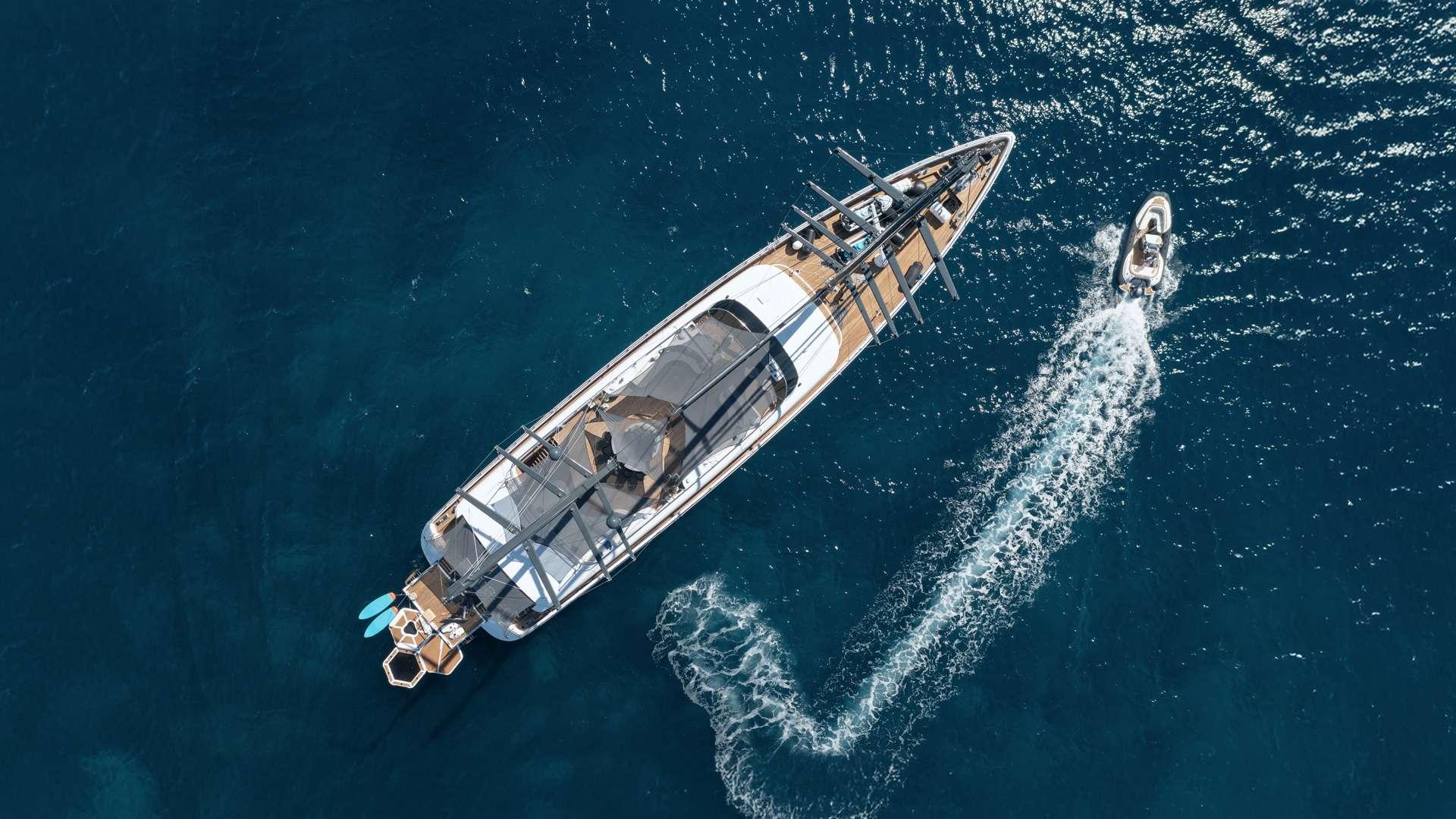 aerial drone shot of luxury gulet yacht with wooden deck and tender boat alongside