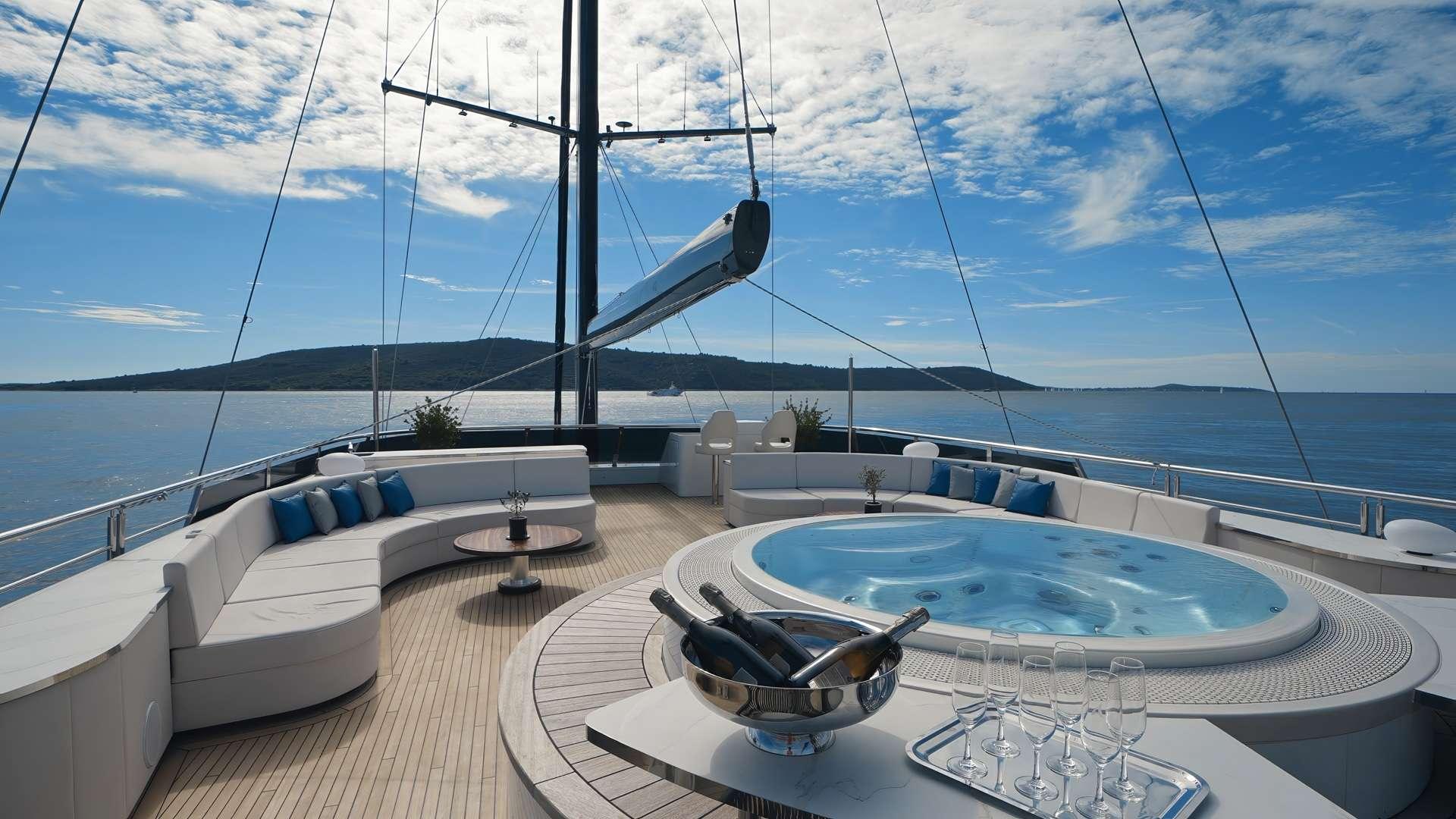 circular jacuzzi with blue water and champagne bucket on luxury yacht sundeck