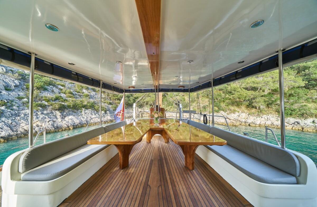 luxury yacht covered aft deck with curved seating and panoramic glass windows