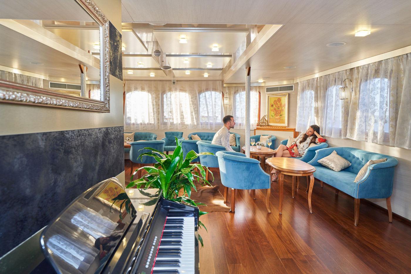 elegant yacht salon interior with grand piano blue seating and guests