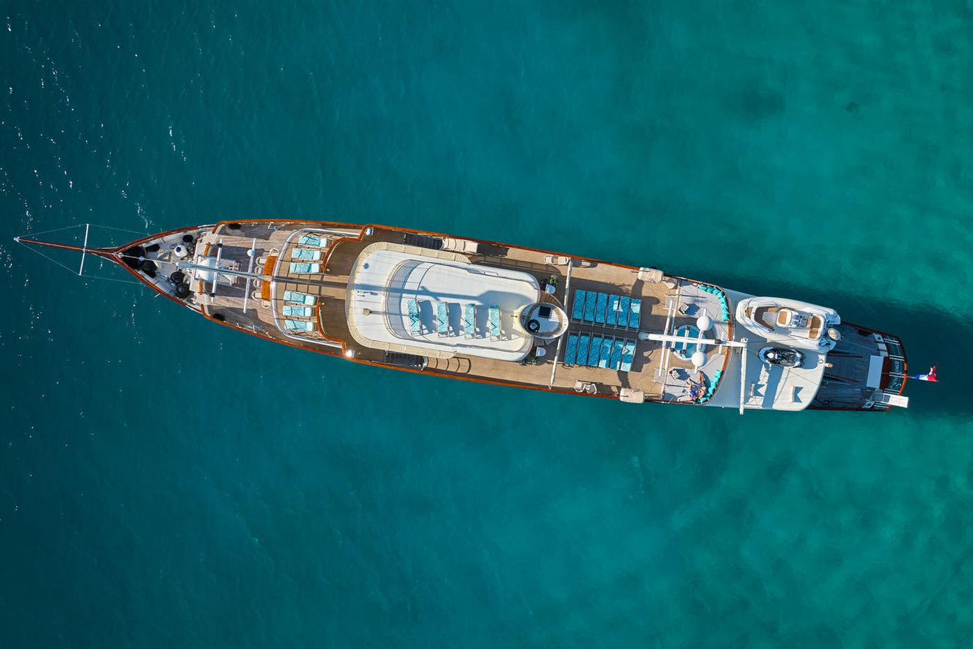 Aerial drone view of luxury motor yacht anchored in crystal clear turquoise waters