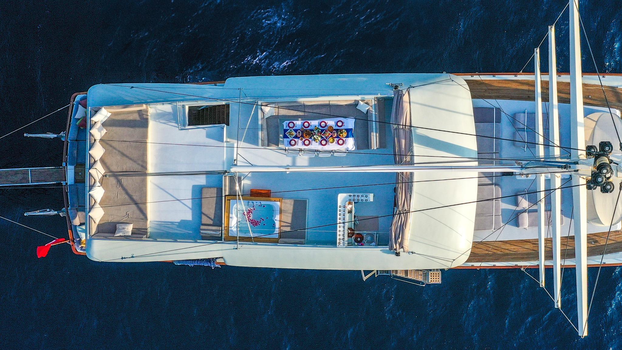 aerial view of white sailing yacht showing aft deck seating area and cockpit layout