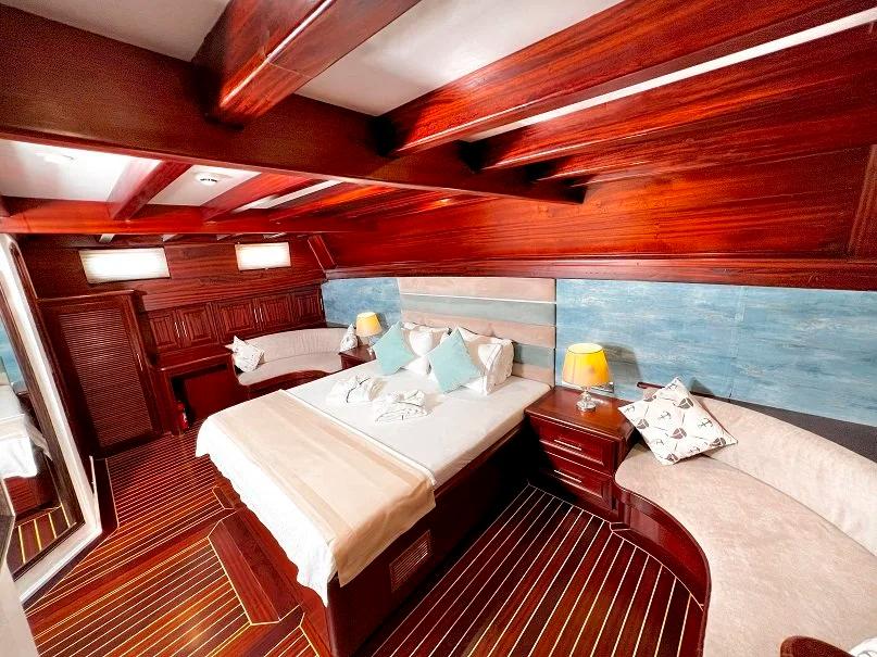 yacht guest cabin featuring double bed with white linens and large panoramic windows