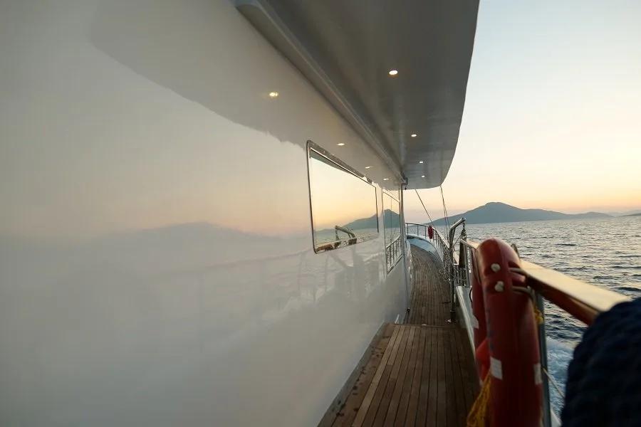 yacht side deck with teak flooring and stainless steel railings during golden hour sunset