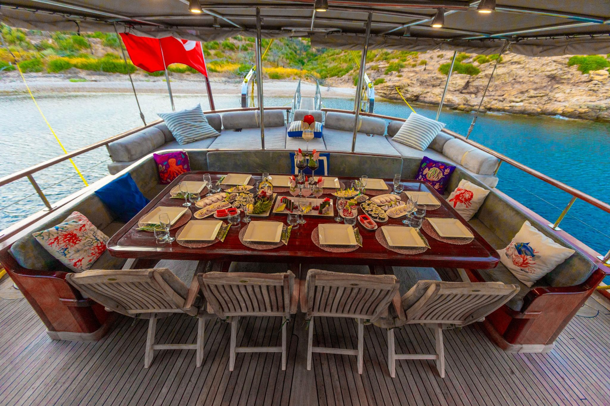 gulet aft deck dining table with served meal and formal place settings