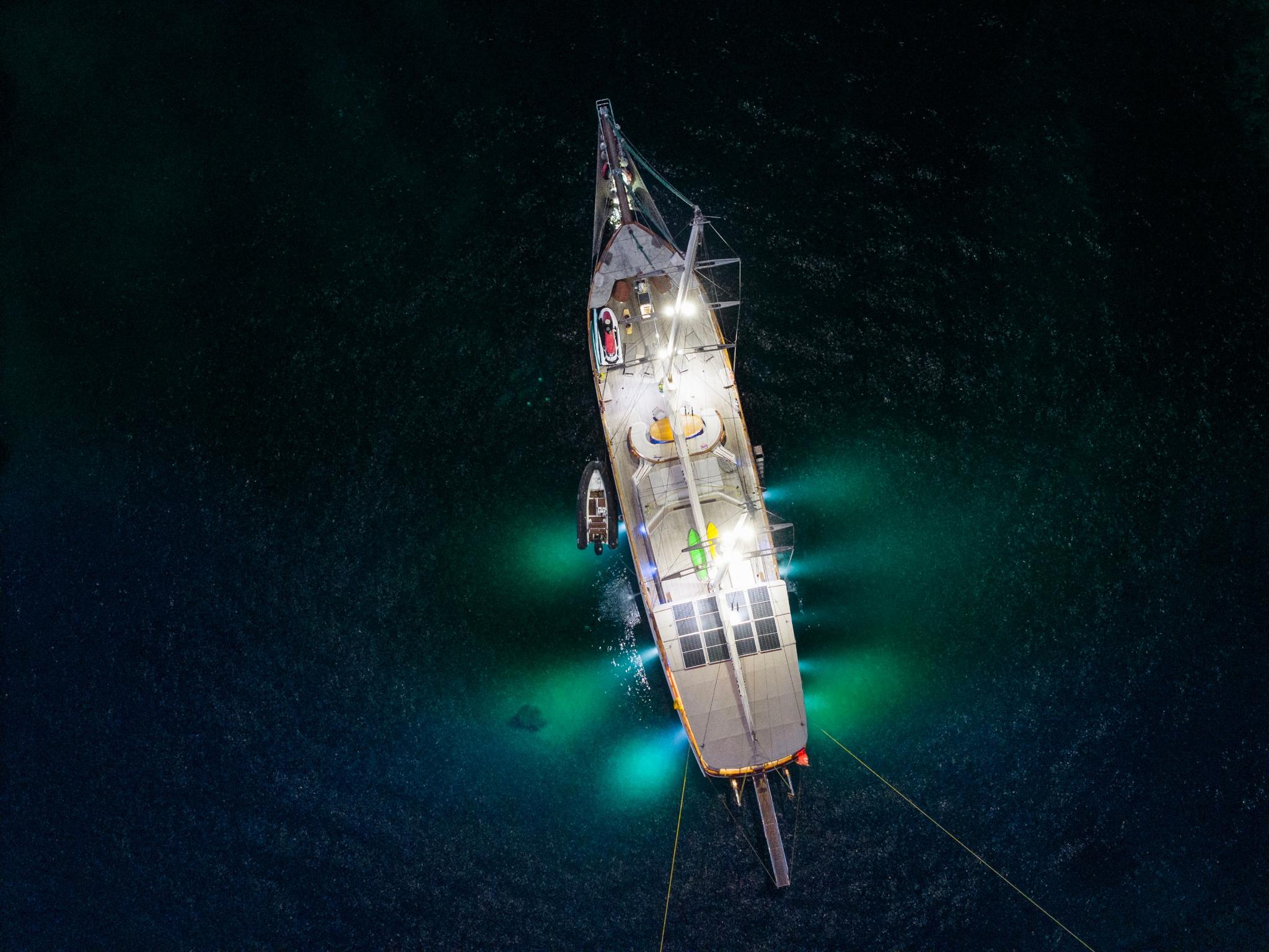aerial drone shot of traditional wooden gulet yacht anchored in crystal clear turquoise waters