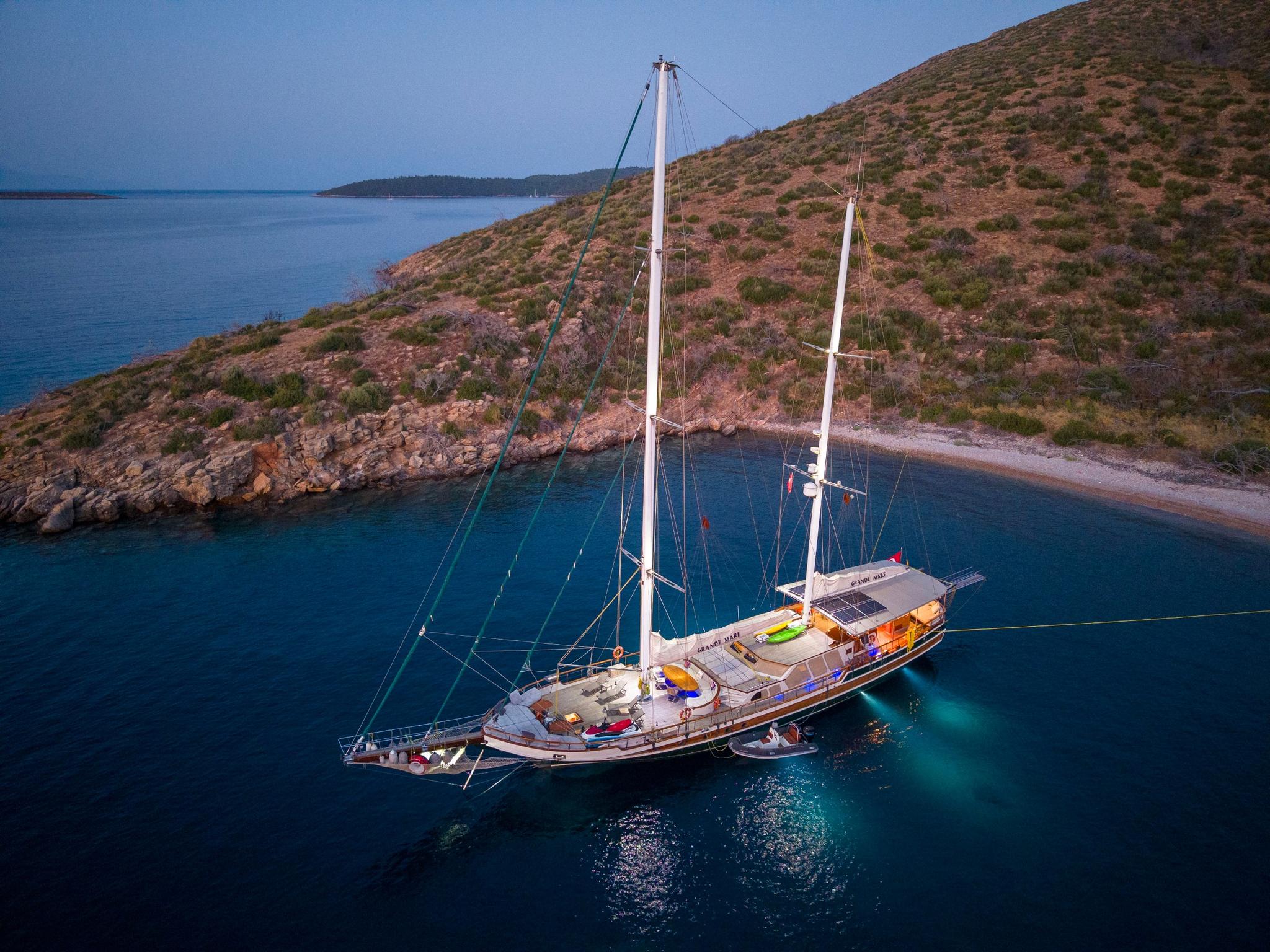 aerial view of traditional wooden gulet yacht anchored in crystal clear turquoise bay