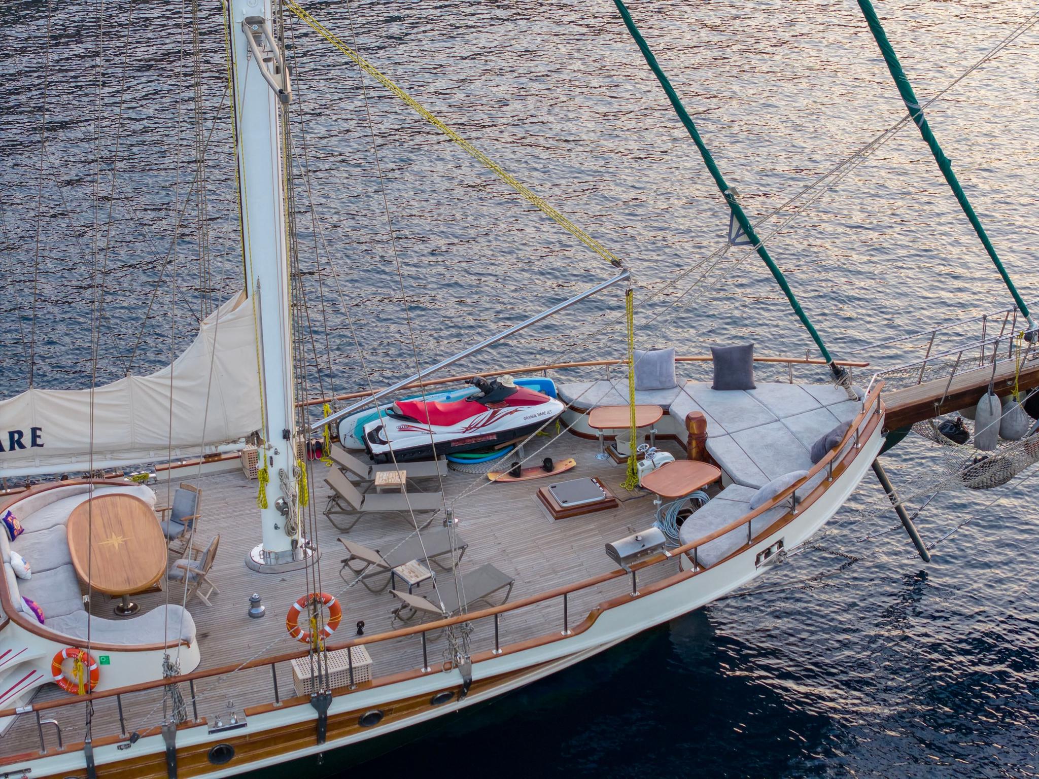 yacht deck with red and white jet ski and water sports equipment