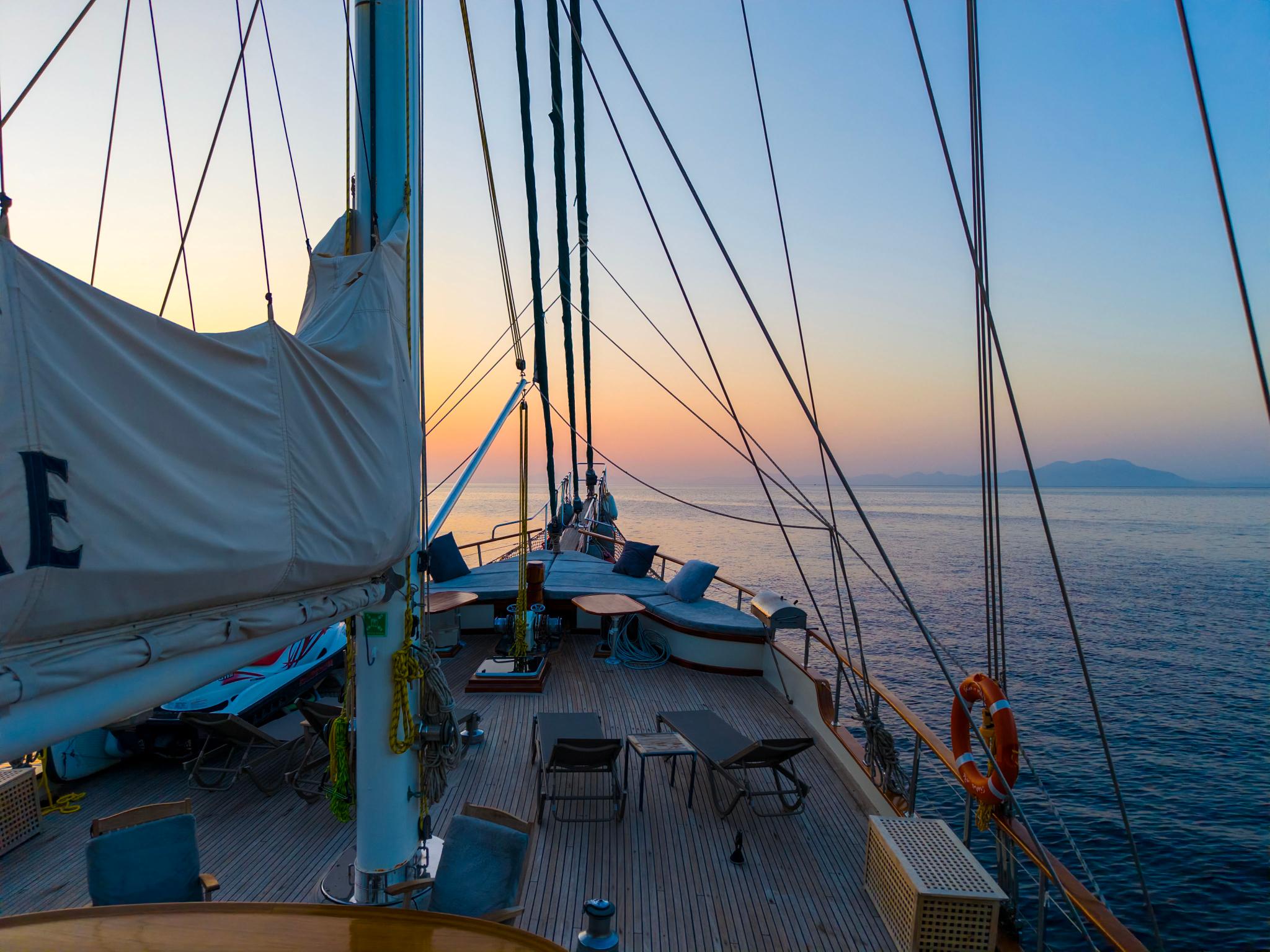 gulet bow deck with wooden planking and rigging during sunset sailing