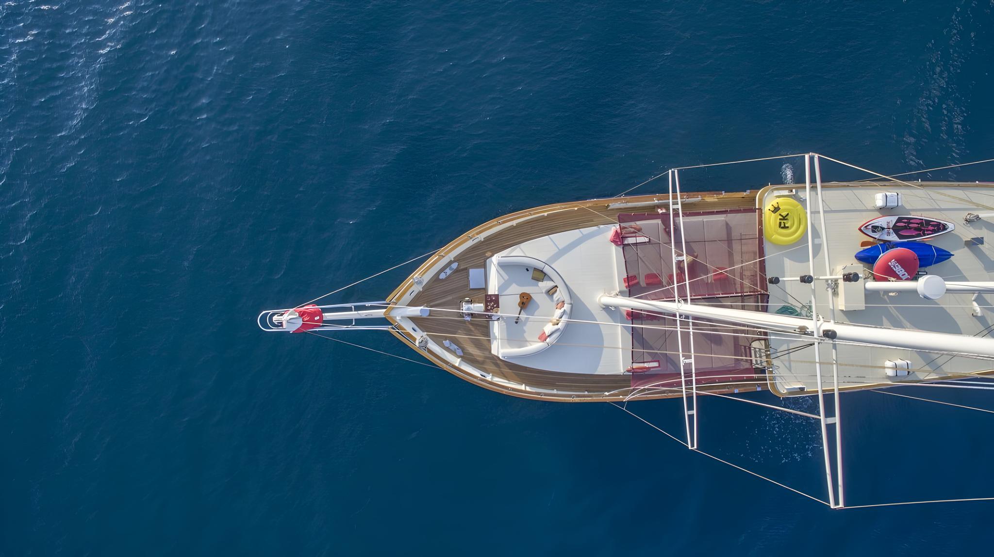 yacht deck showing colorful kayaks and paddleboards stored as water sports equipment