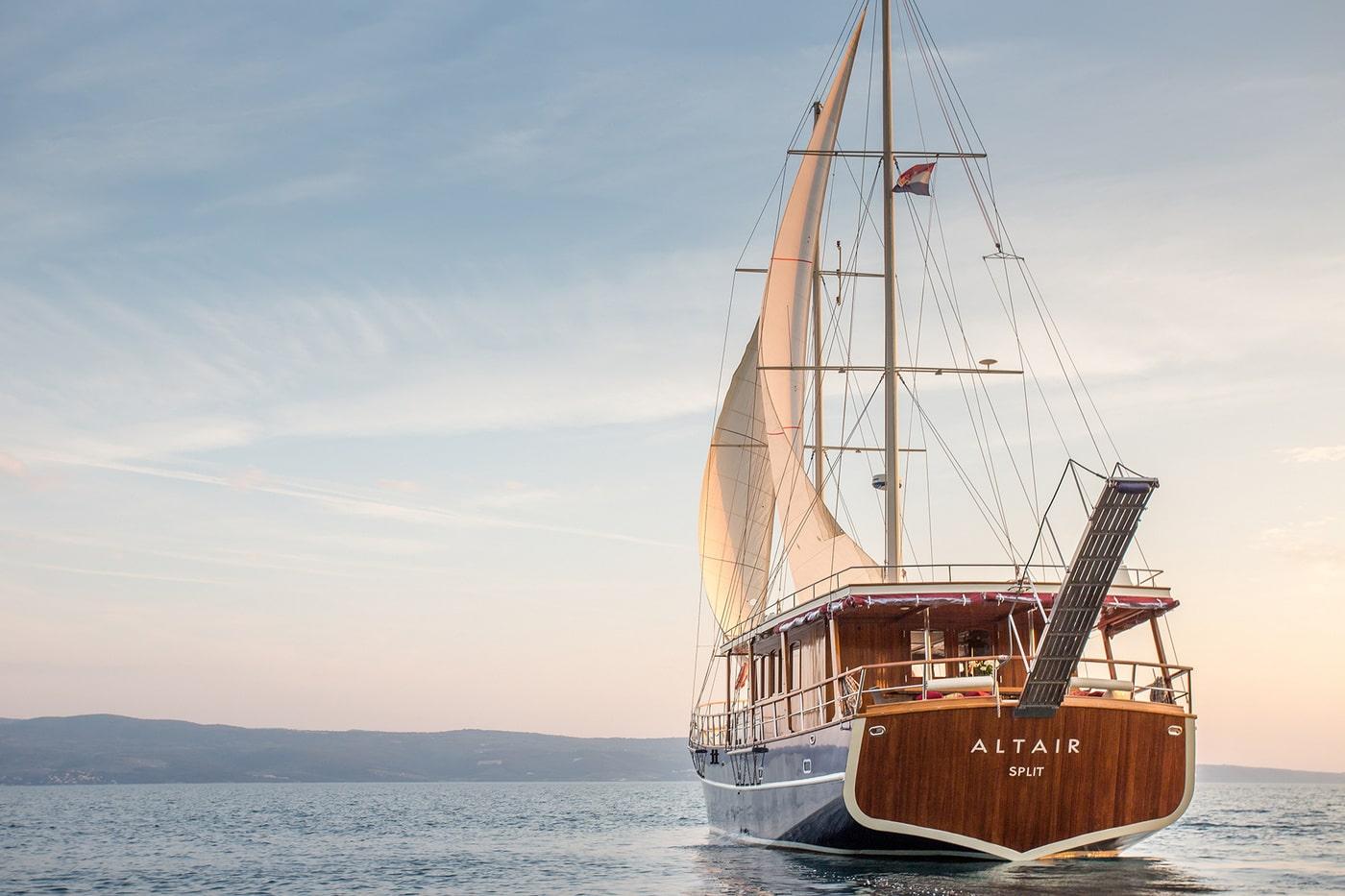Luxury gulet Altair from Split sailing with cream sails at sunset