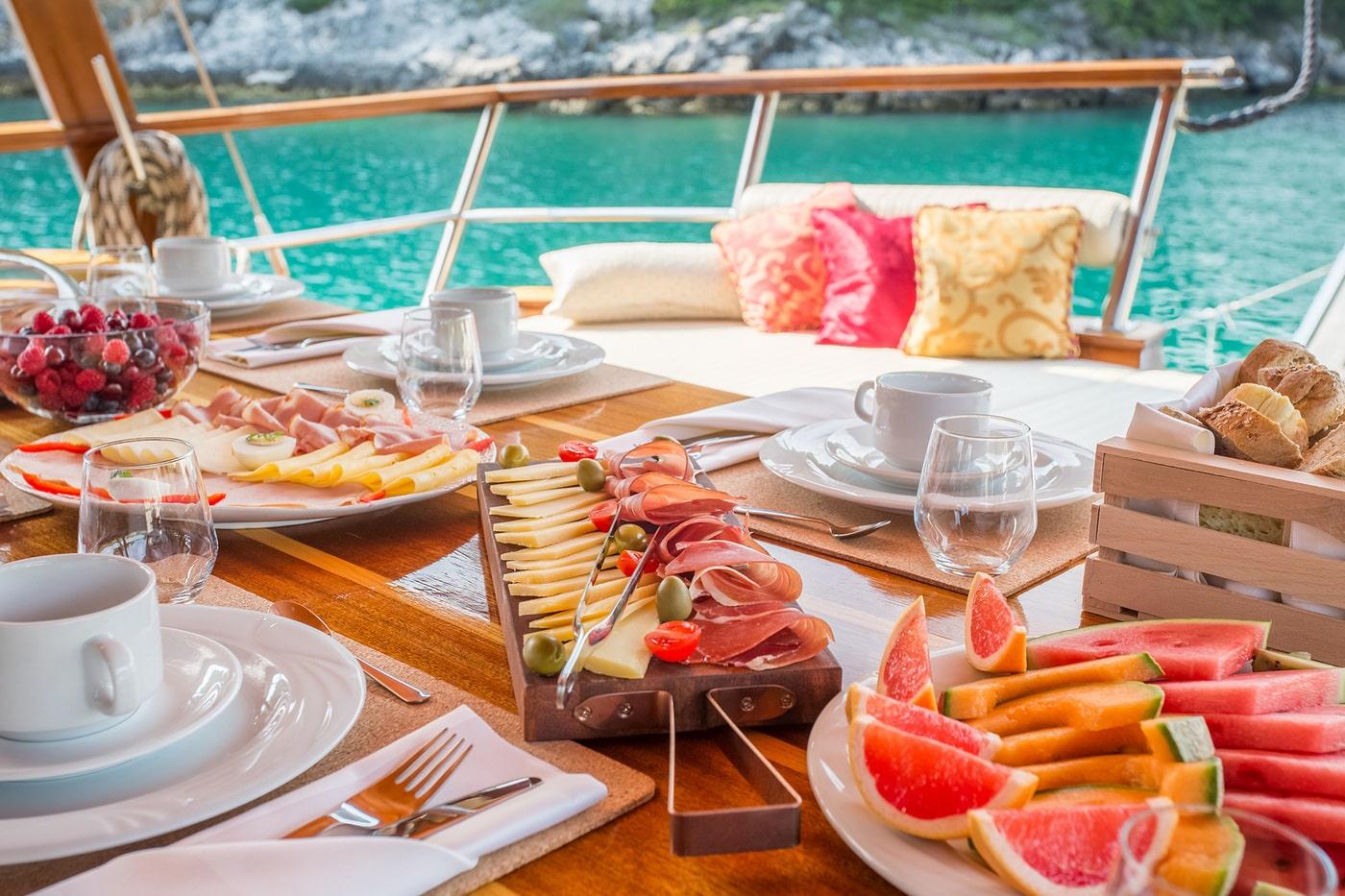elegant breakfast spread on luxury yacht deck with turquoise Mediterranean waters
