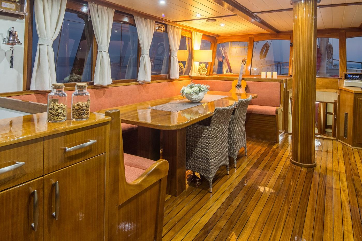 elegant yacht salon with teak woodwork coral seating dining table