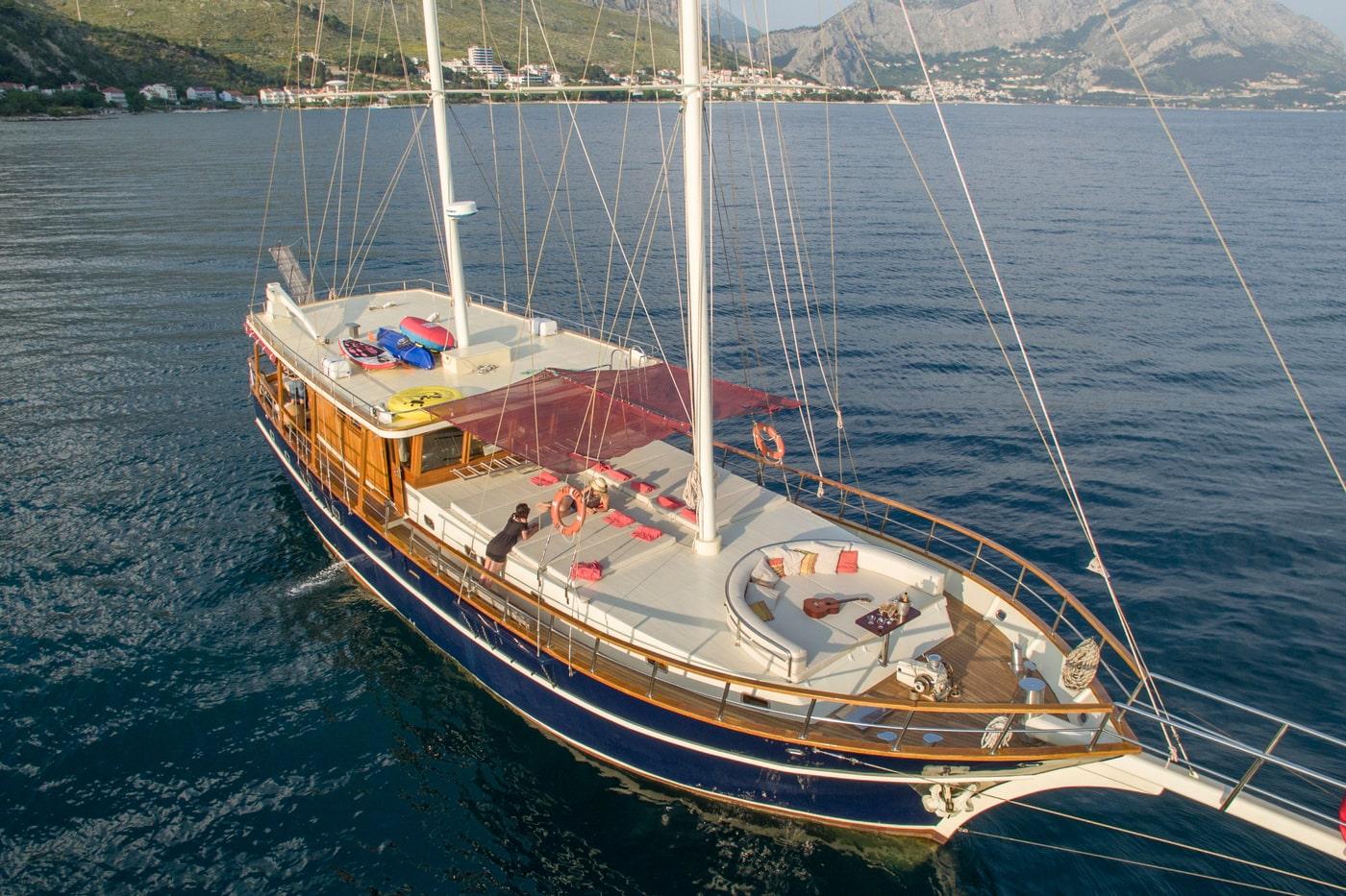 Aerial view of traditional wooden gulet yacht with colorful water toys anchored in Mediterranean bay