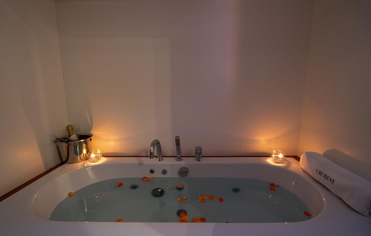 yacht jacuzzi filled with water and scattered orange flower petals with candles