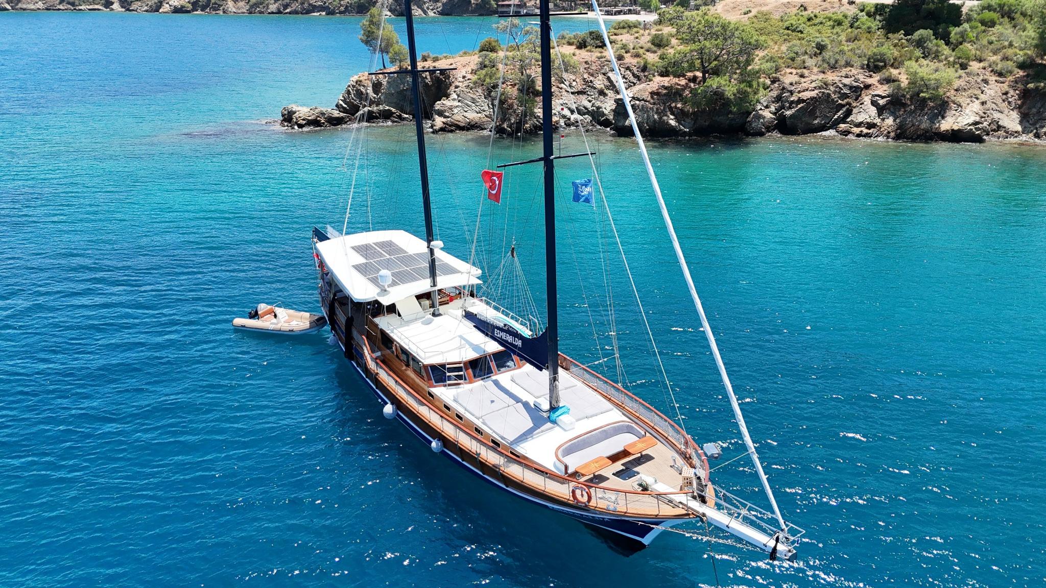 aerial view of traditional wooden gulet yacht anchored in crystal clear turquoise Mediterranean waters