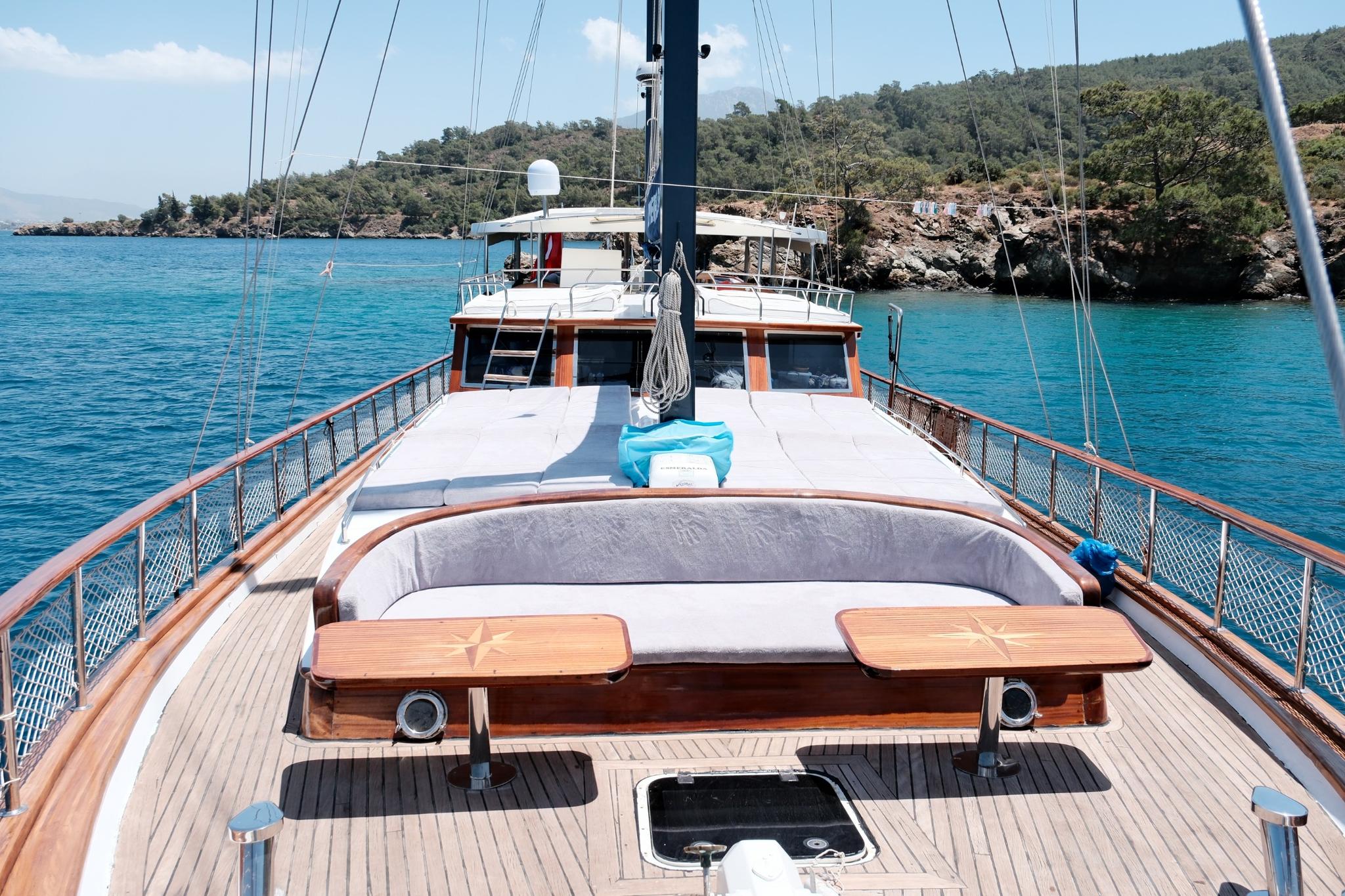 gulet bow deck with curved cushioned seating bench and teak decking in turquoise bay
