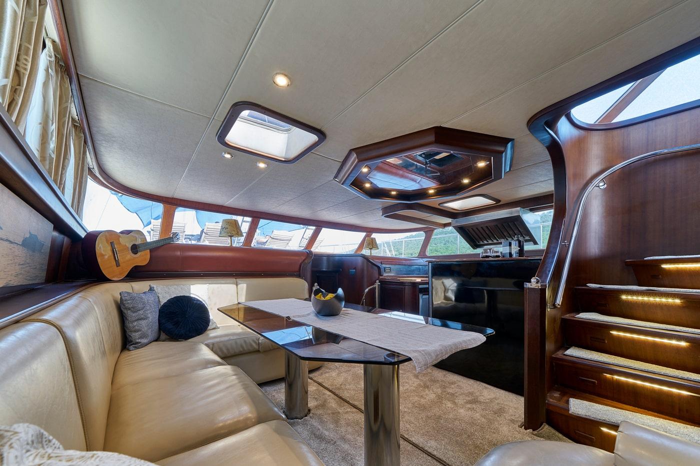 yacht salon interior with cream leather seating, coffee table and panoramic side windows