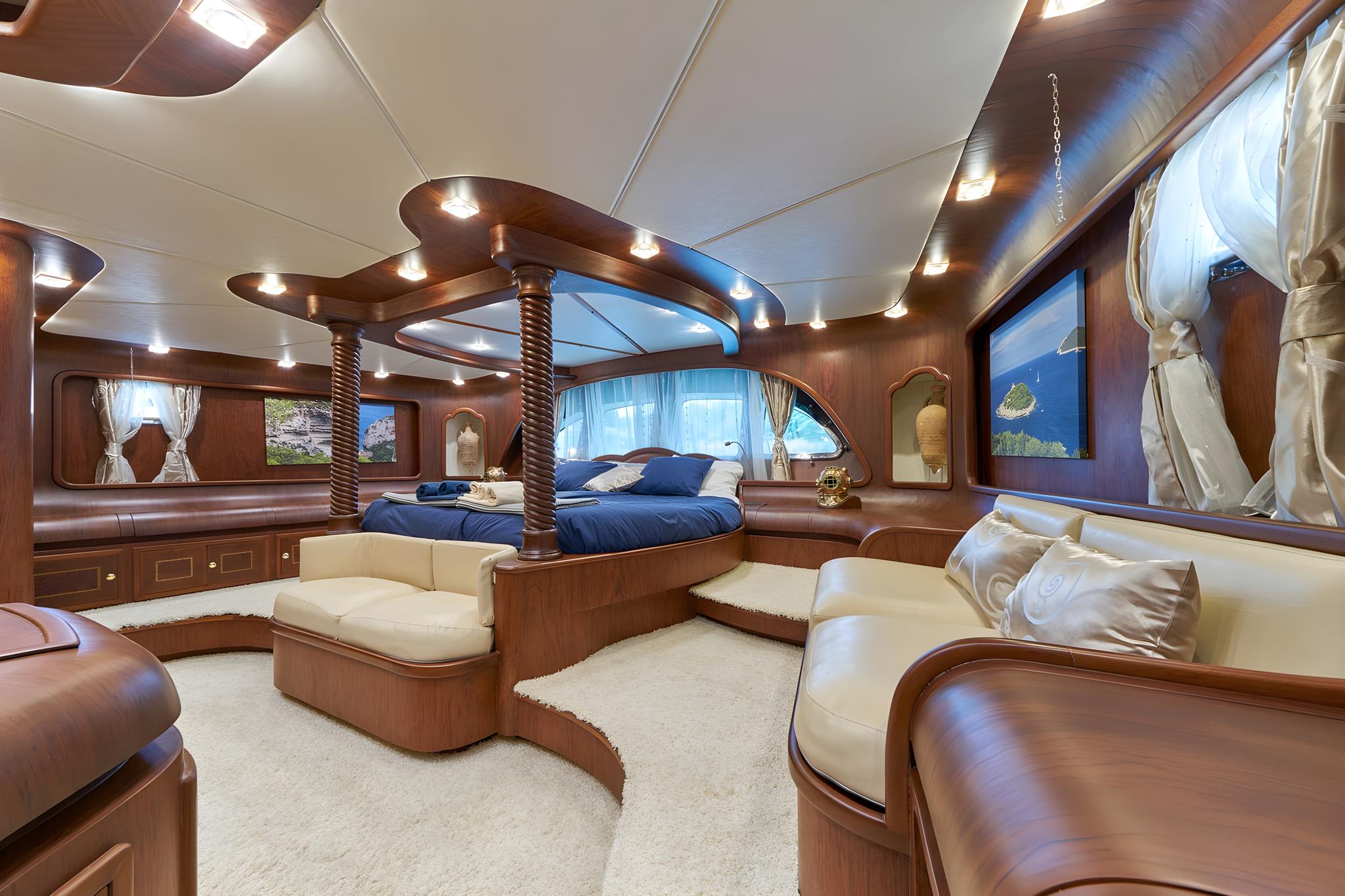 luxury yacht master cabin featuring circular bed with twisted rope posts and cream leather seating
