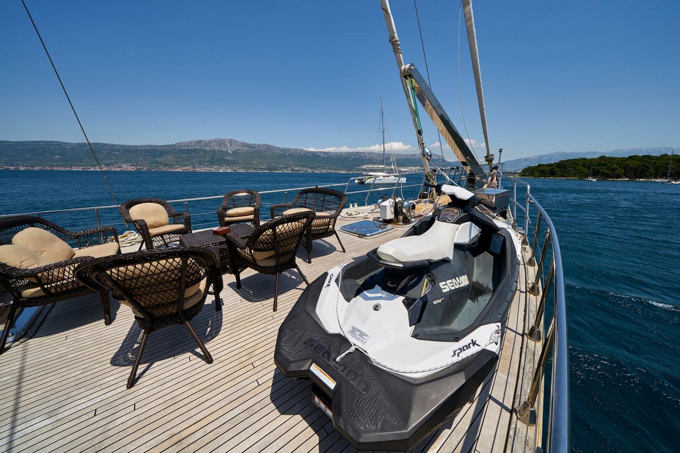 Sea-Doo Spark jet ski positioned on yacht's teak deck with wicker outdoor seating