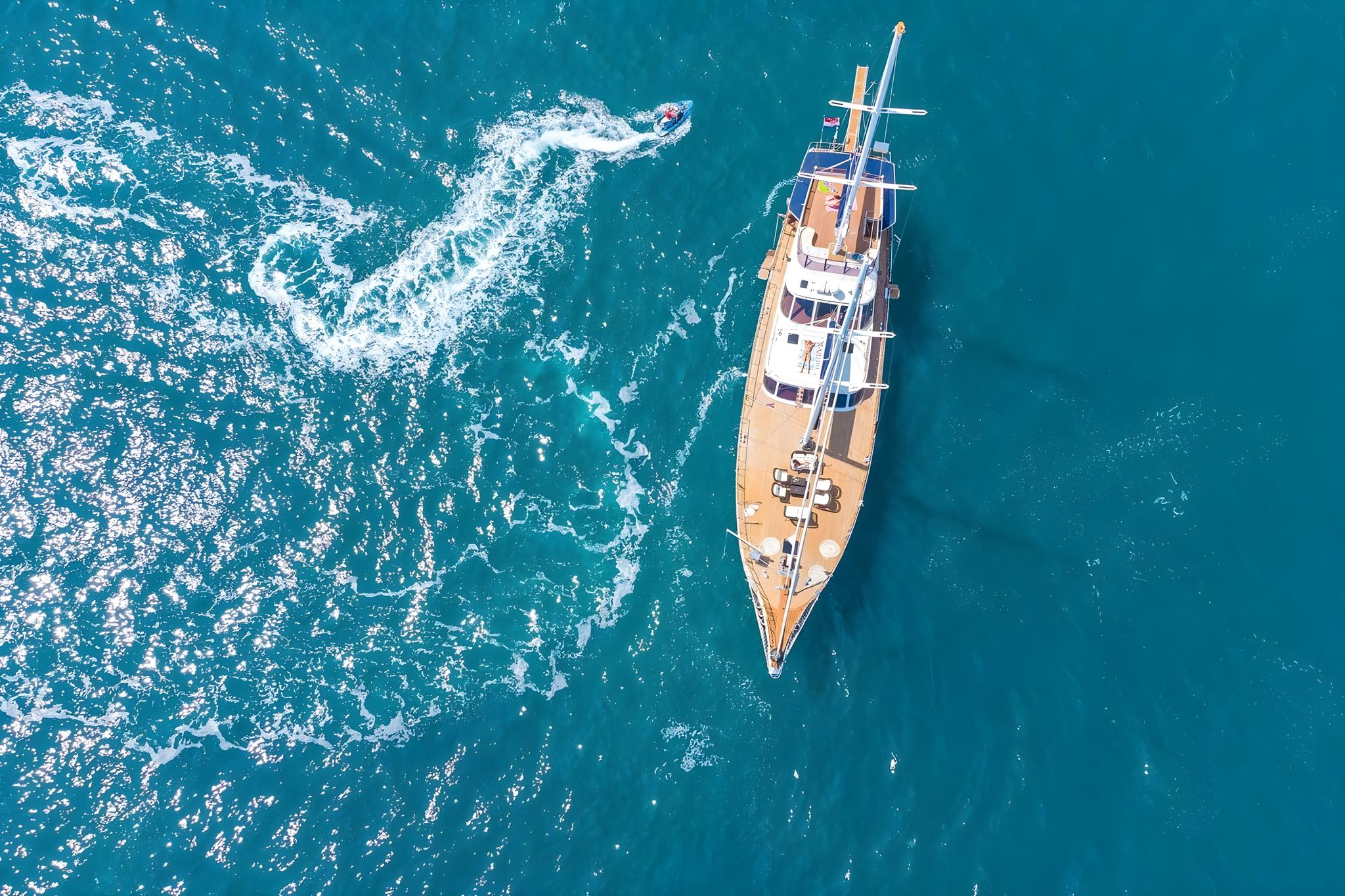 aerial view of traditional wooden gulet yacht anchored in crystal clear turquoise Mediterranean waters