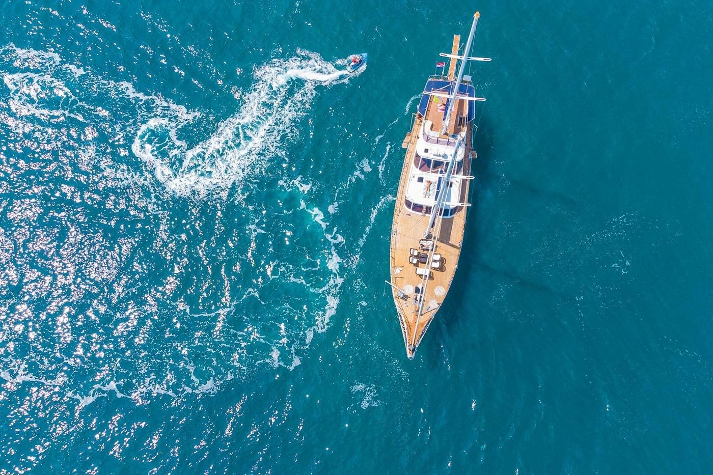 aerial view of traditional wooden gulet yacht anchored in crystal clear turquoise Mediterranean waters