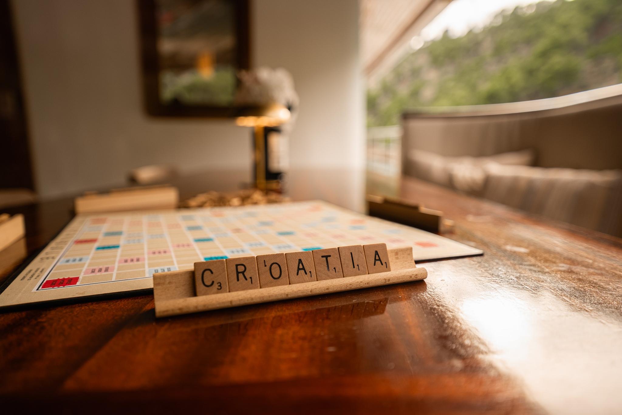 Scrabble board game with Croatia tiles on yacht dining table