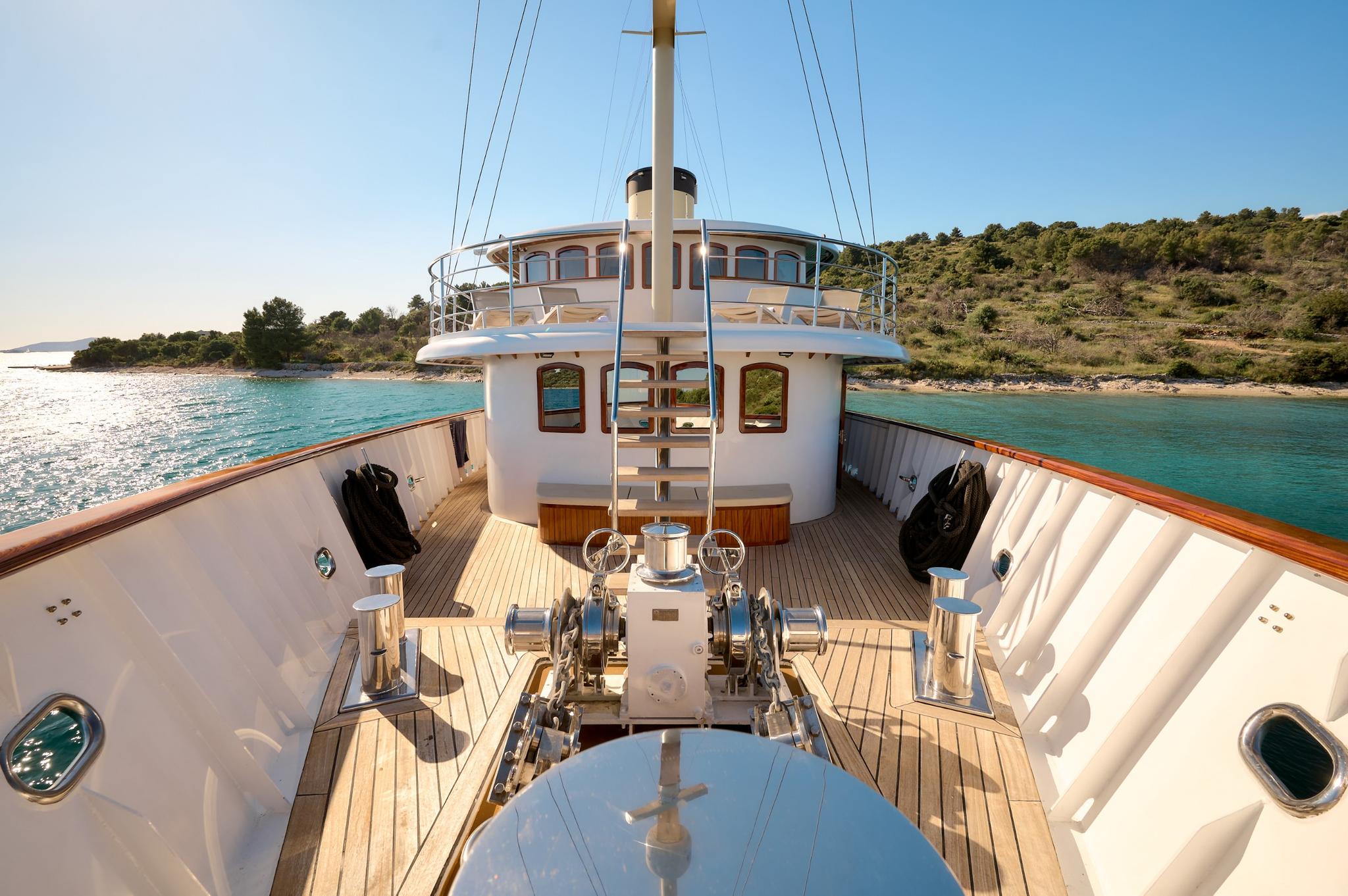 gulet forward deck with teak planking, white wheelhouse, and anchor windlass equipment