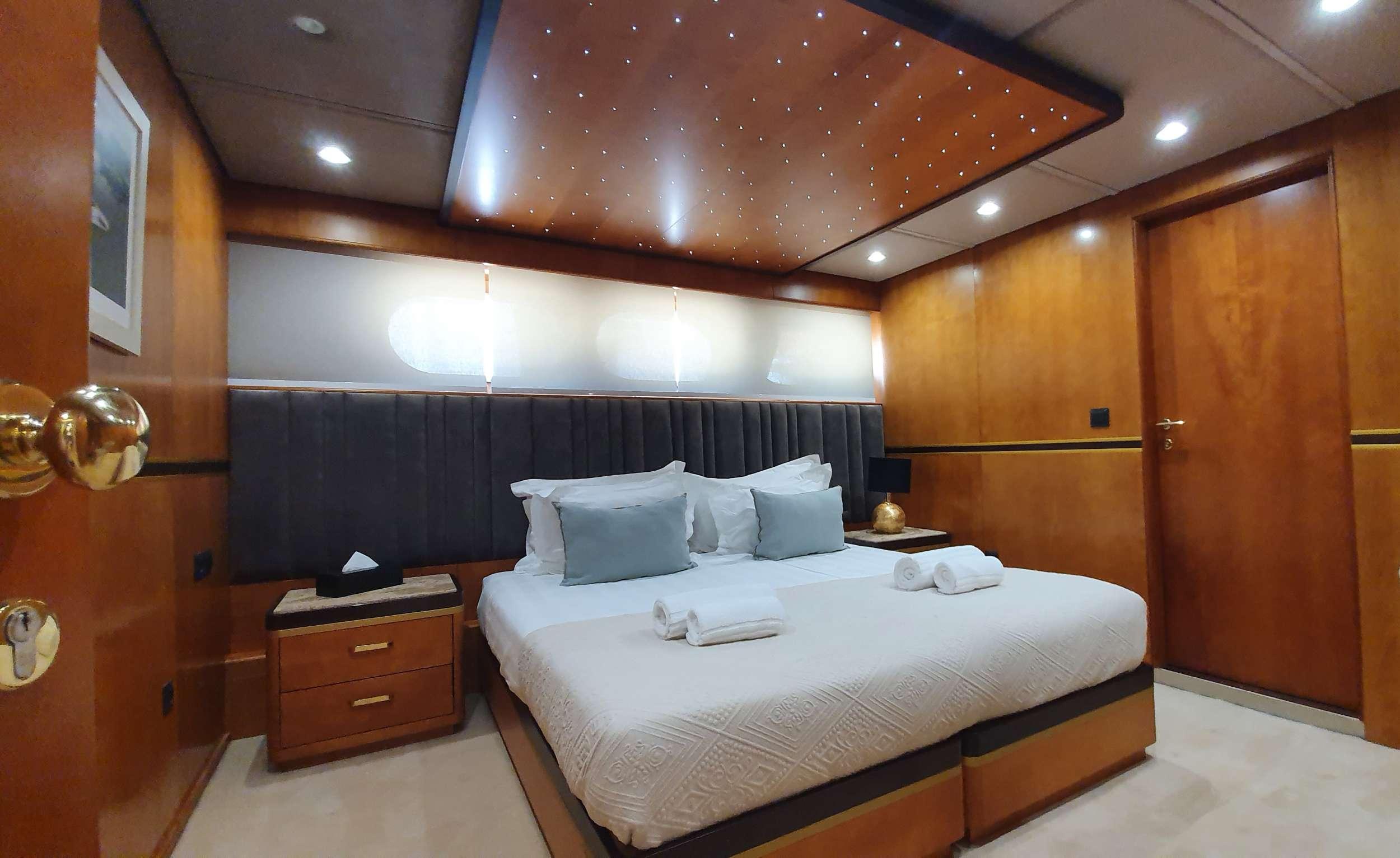 Luxury master cabin with king bed, teal cushions, and fibre optic star ceiling on a gulet
