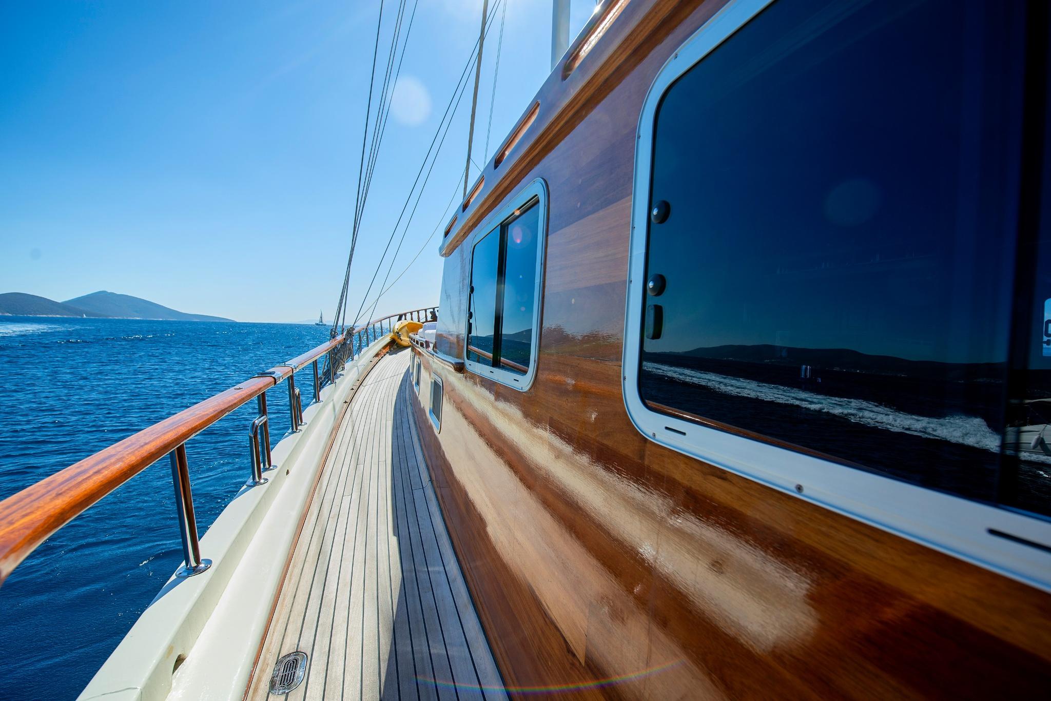 gulet side deck with teak planking, stainless steel handrails and large windows