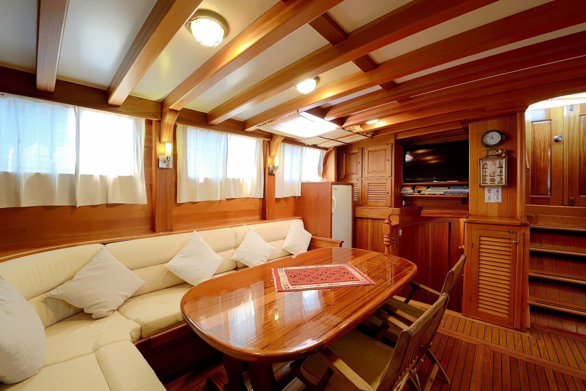 yacht salon with cream leather seating, wooden coffee table and built-in entertainment unit