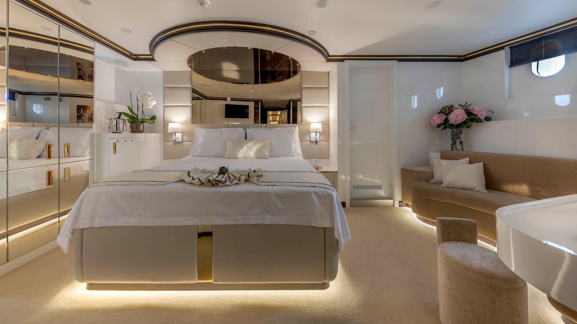 spacious yacht master cabin featuring king bed, mirrored ceiling, built-in wardrobes and seating area