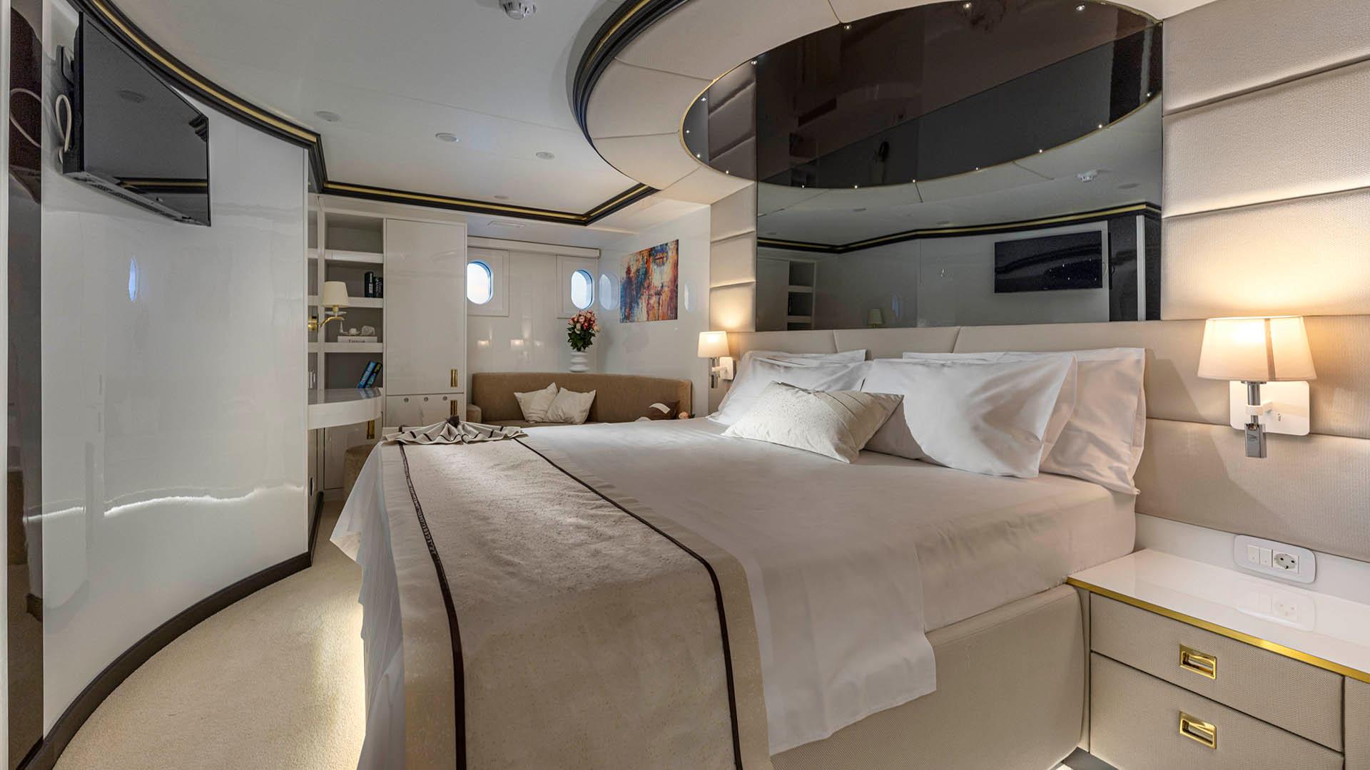 yacht master cabin featuring king bed, built-in wardrobes, portholes and curved ceiling design