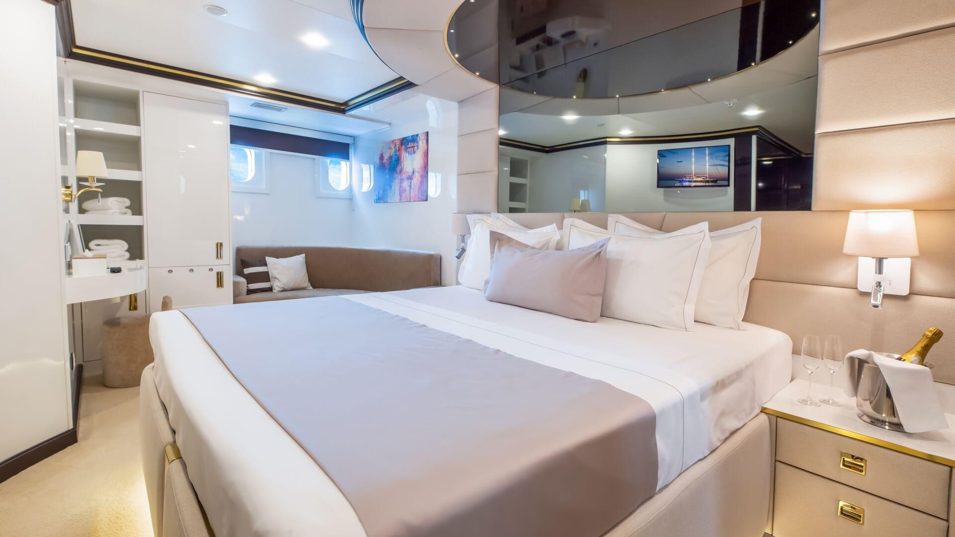 Yacht master cabin with king bed, white linens, built-in storage and ensuite bathroom