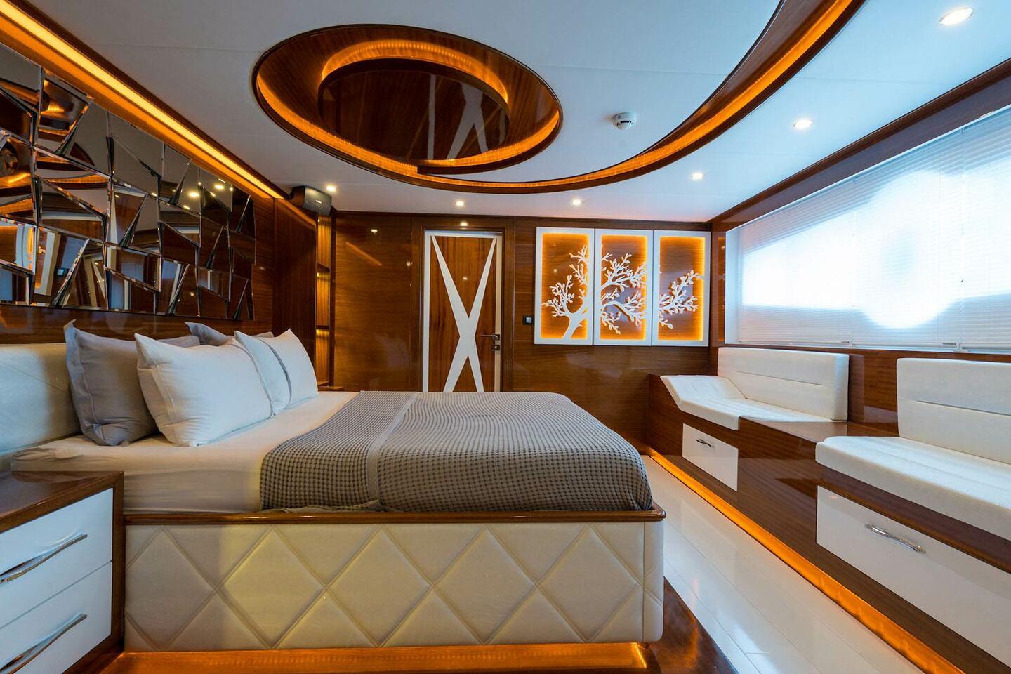 Master cabin featuring king bed, oval skylight, mirrored headboard and panoramic windows