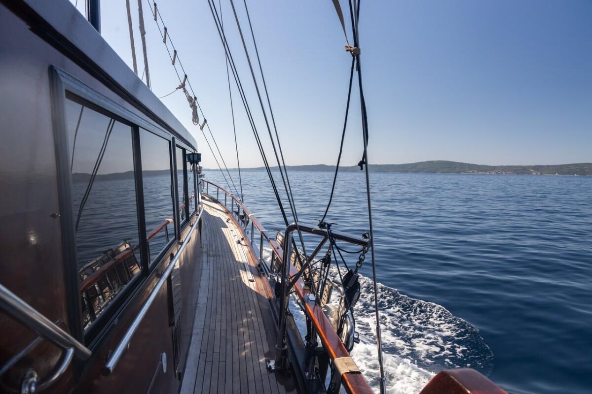 gulet side deck with teak planking, stainless steel railings and rigging while underway