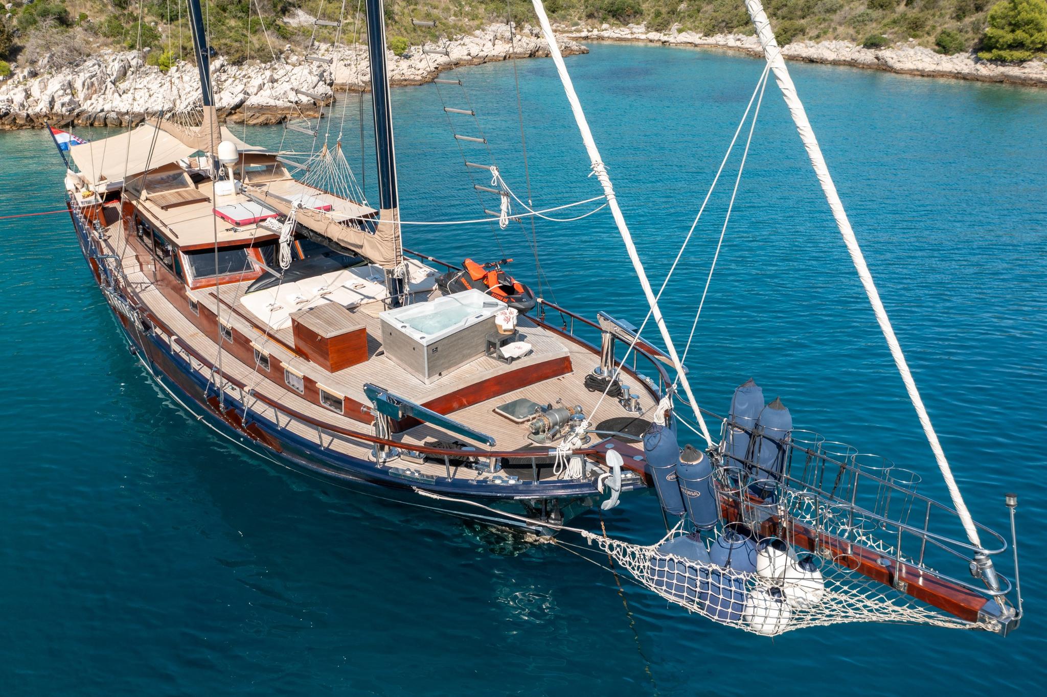 Aerial view of traditional wooden gulet yacht anchored in turquoise Mediterranean bay