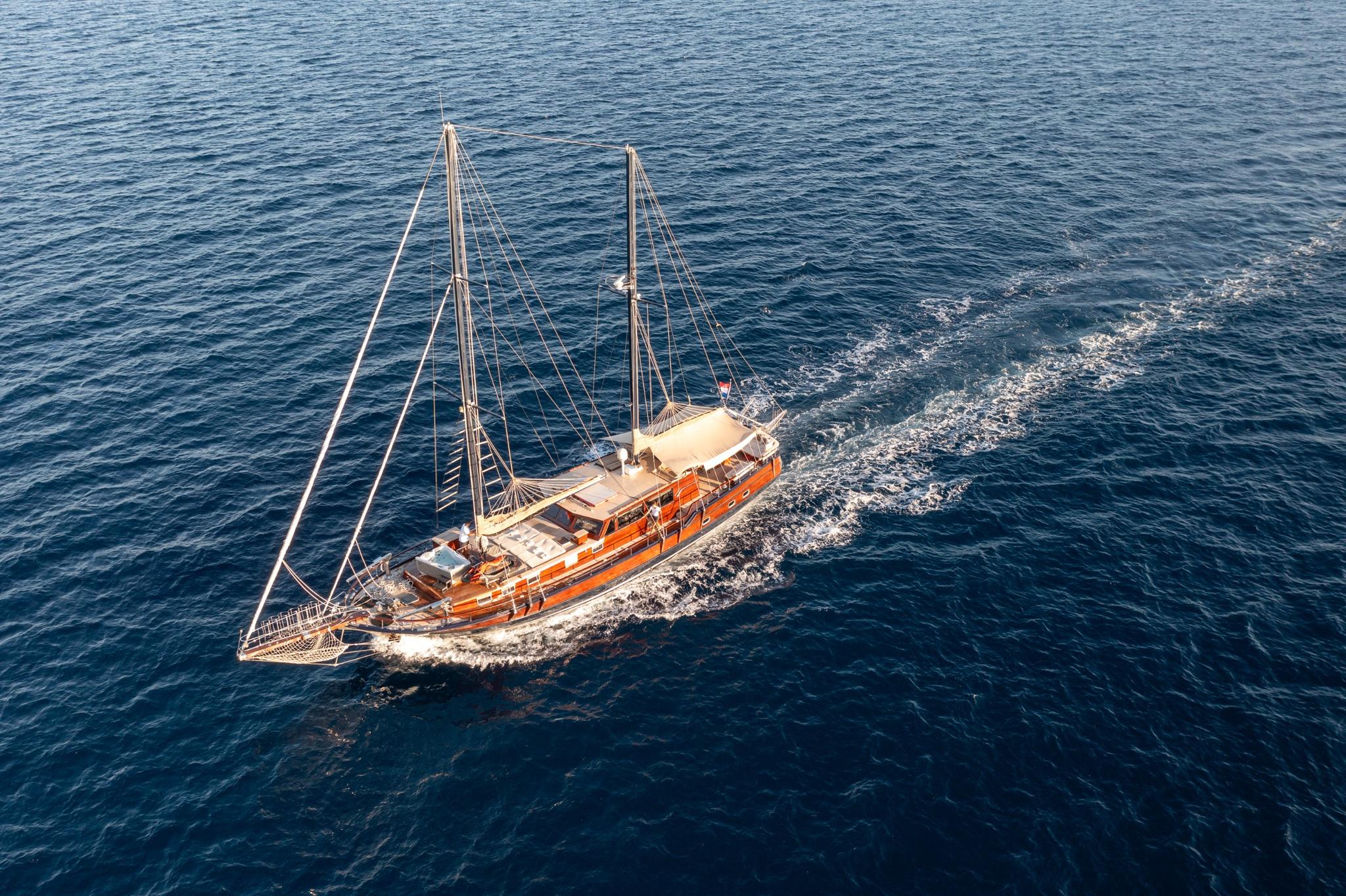 aerial view of traditional wooden gulet yacht under sail on blue Mediterranean waters