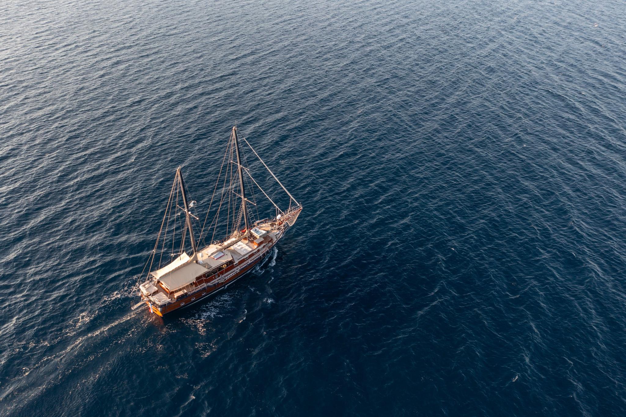 aerial view of traditional wooden gulet with two masts sailing in deep blue waters