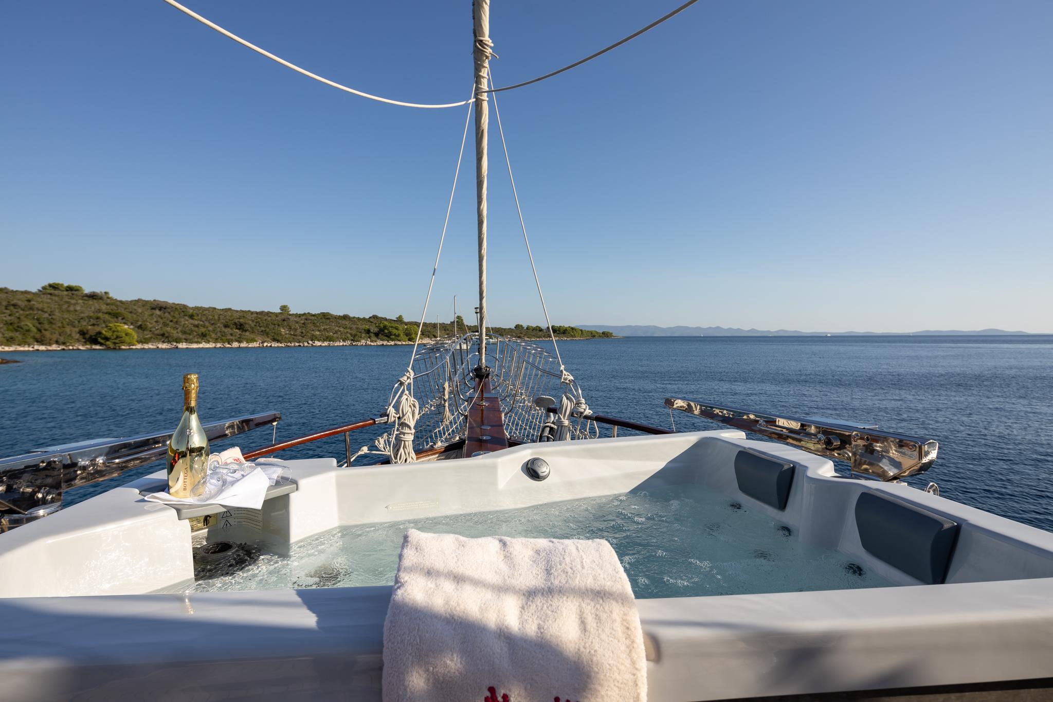 onboard jacuzzi with champagne bottle and towels on yacht deck