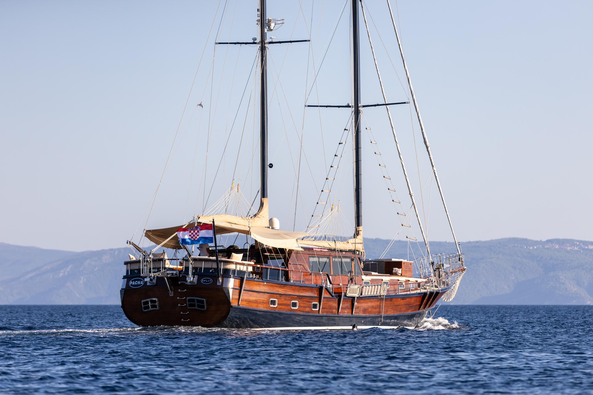 wooden gulet yacht with two masts sailing in Mediterranean waters with Croatian flag