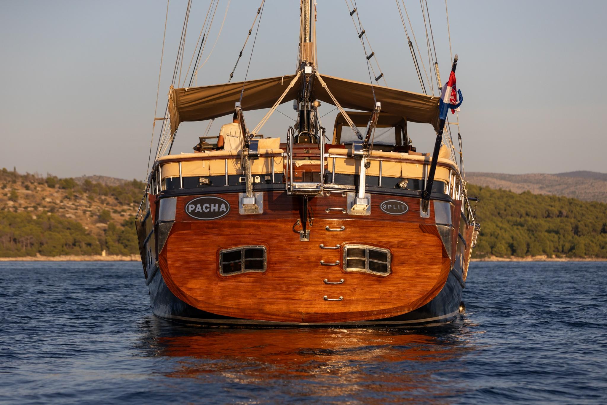 Traditional wooden gulet stern with PACHA SPLIT nameplate and classic rigging at anchor