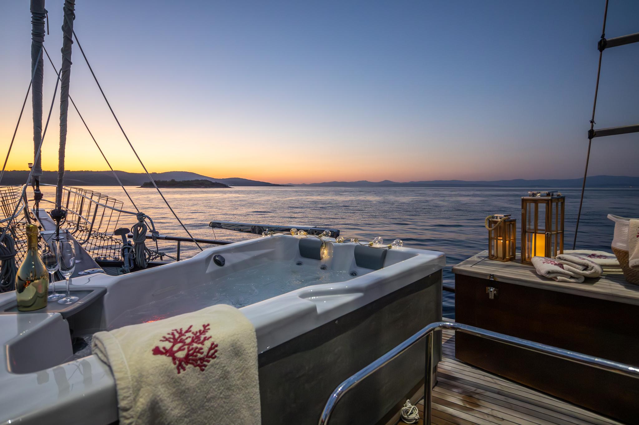 onboard jacuzzi hot tub on sailing yacht deck during golden hour sunset