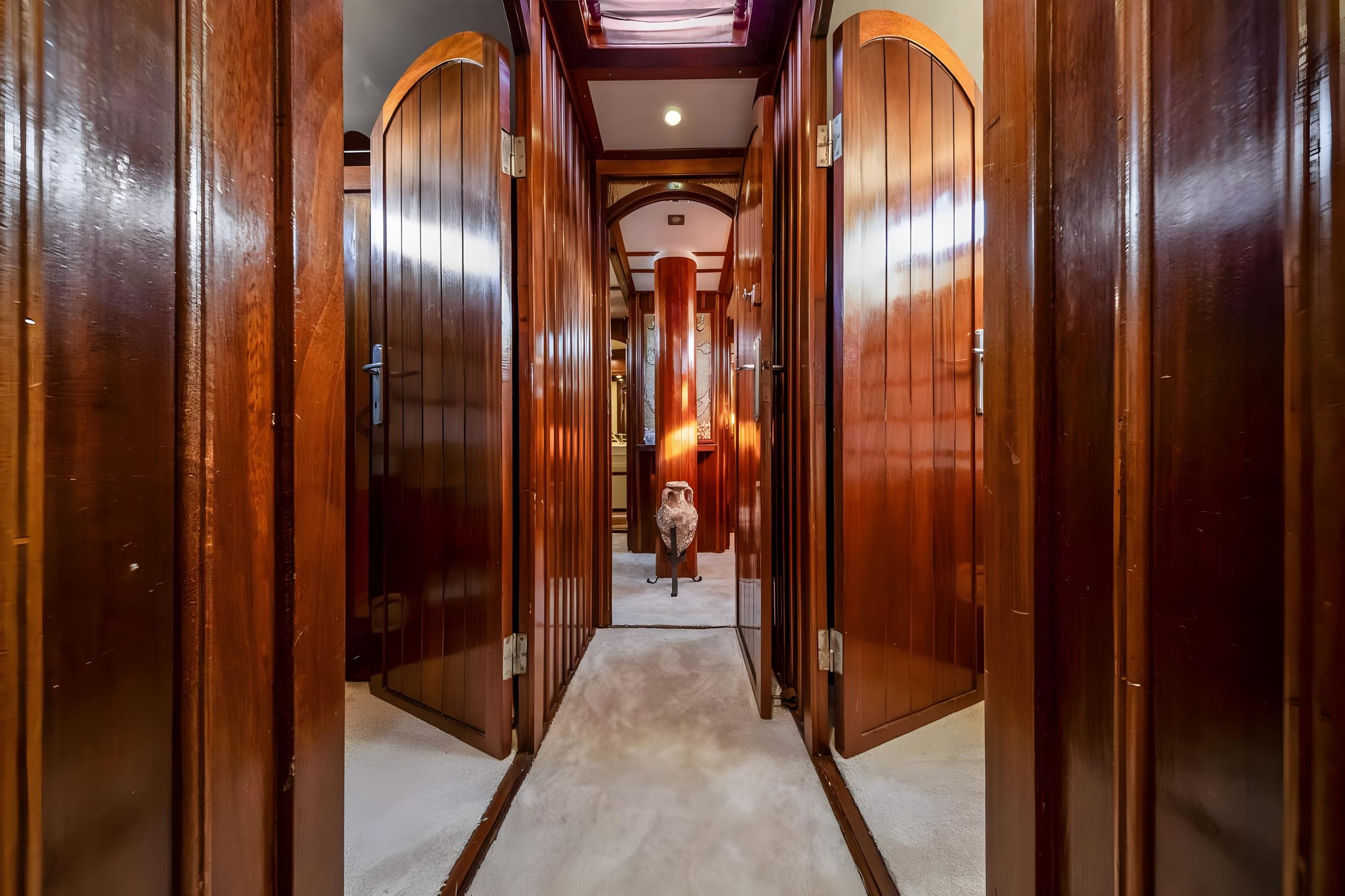 luxury yacht corridor with polished wood paneling and arched cabin doors