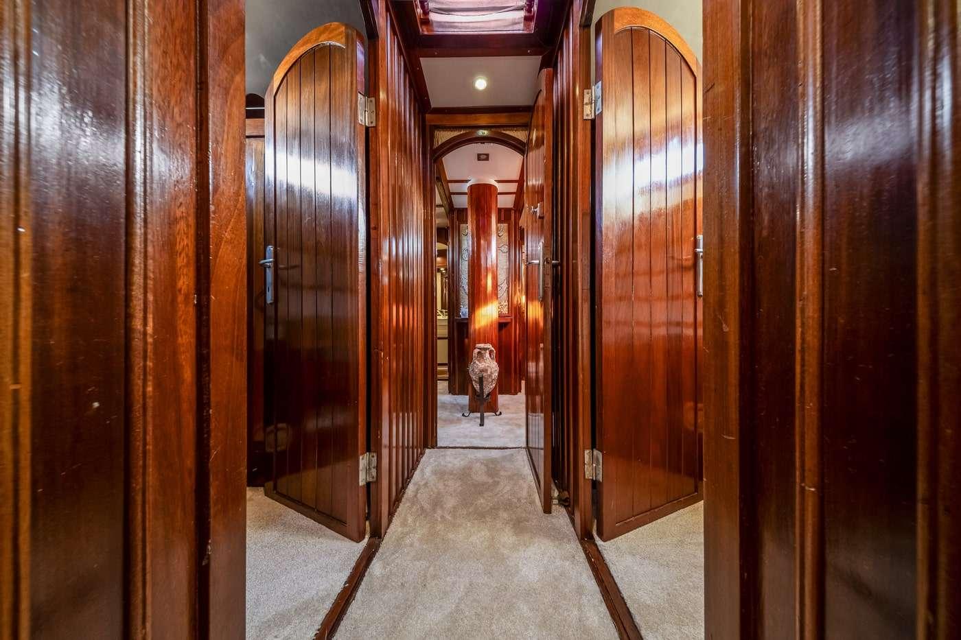 luxury yacht corridor with polished wood paneling and arched cabin doors