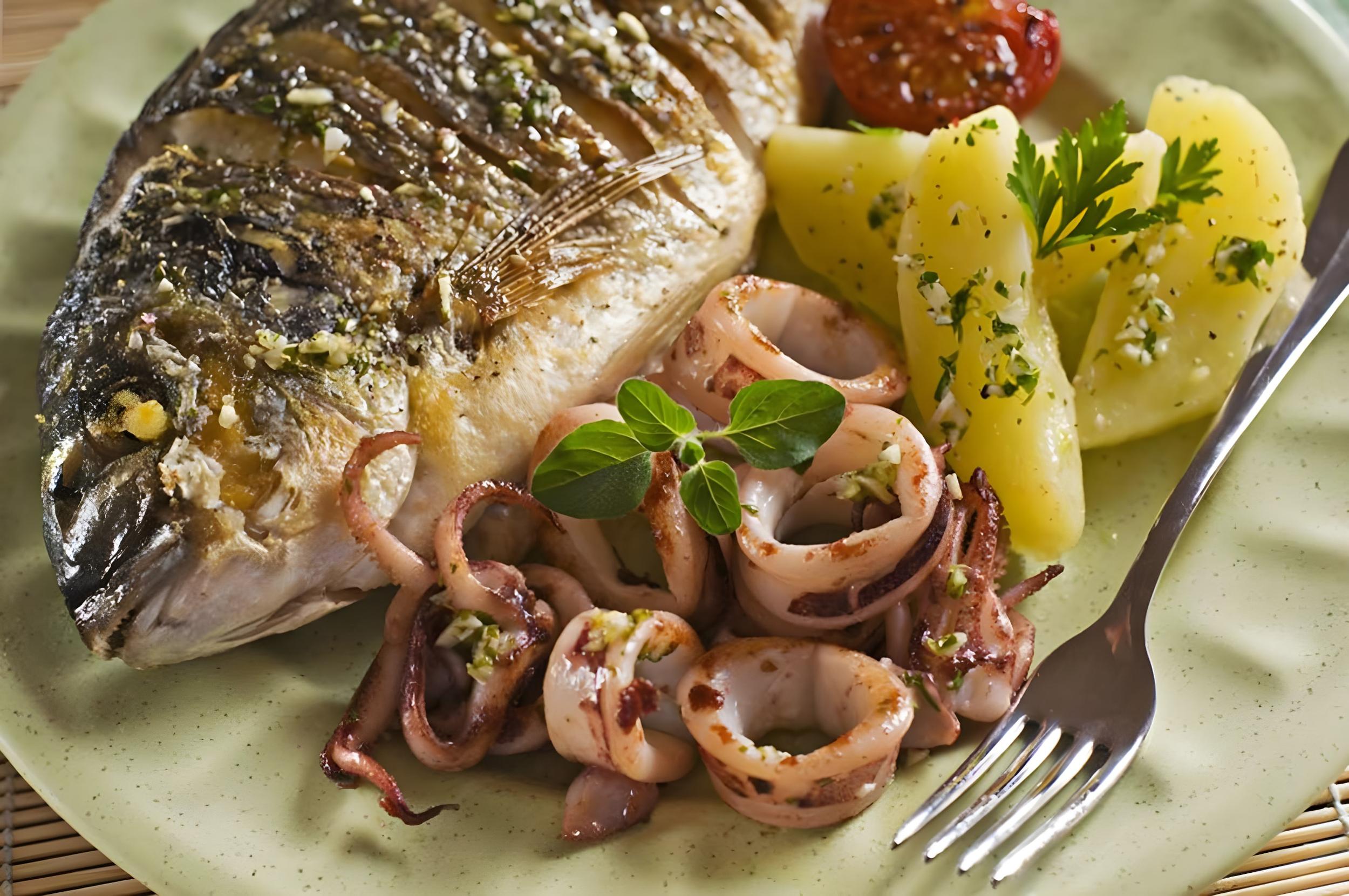 Freshly grilled whole sea bream served with sautéed baby squid and herb-seasoned boiled potatoes on a gulet charter