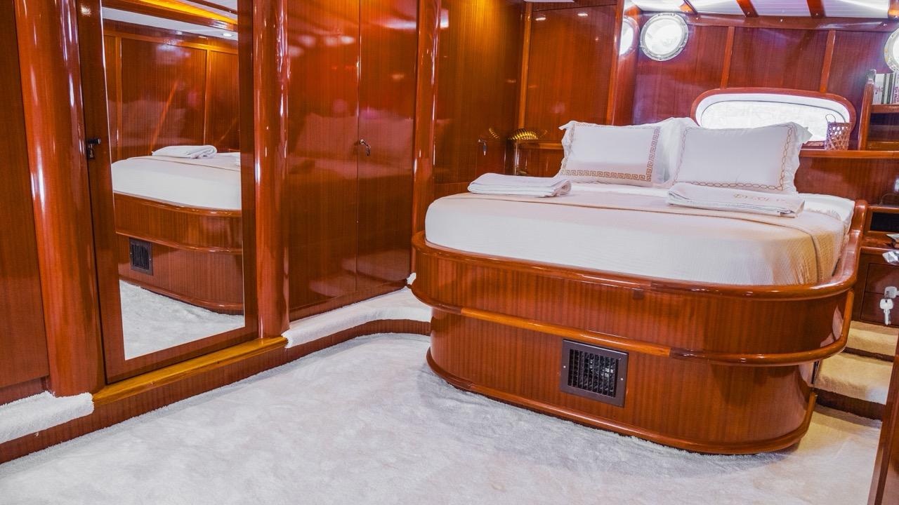 yacht guest cabin featuring double bed with white linens and built-in mirrored wardrobes