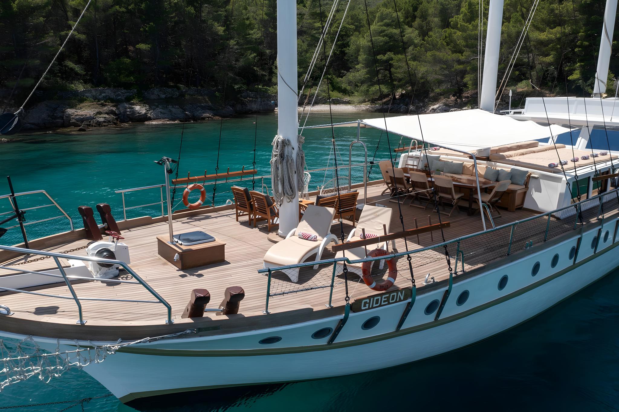 Traditional gulet yacht GIDEON with teak decking anchored in crystal clear Mediterranean waters