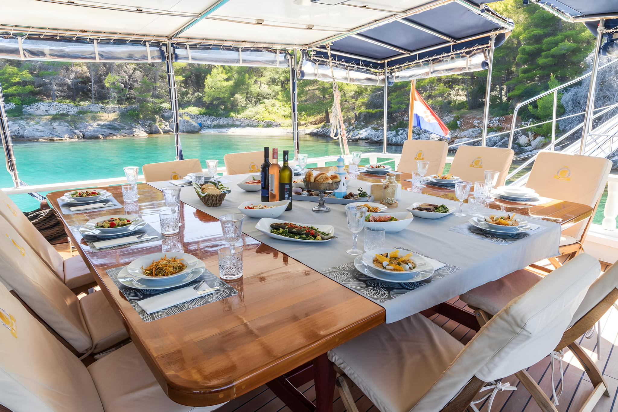 Luxury gulet aft deck dining setup with prepared Mediterranean cuisine