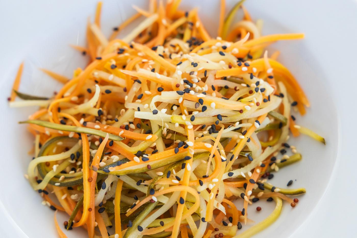 Colorful julienned vegetable salad with carrot, cucumber, bean sprouts and black sesame seeds